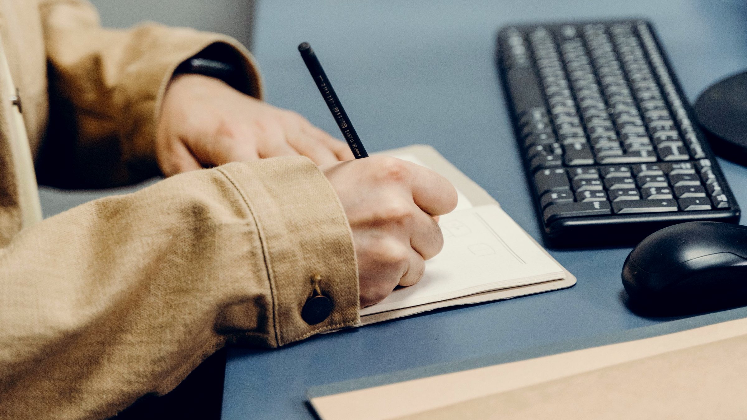 Hands marking printed sheets around a table