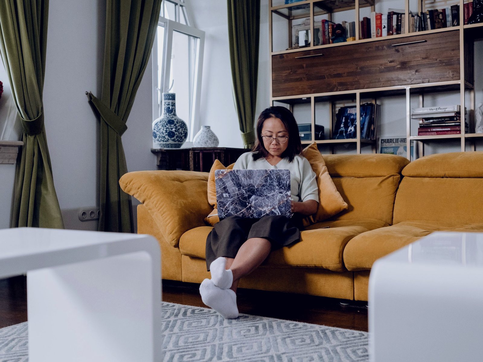 A woman studying on a laptop on a sofa