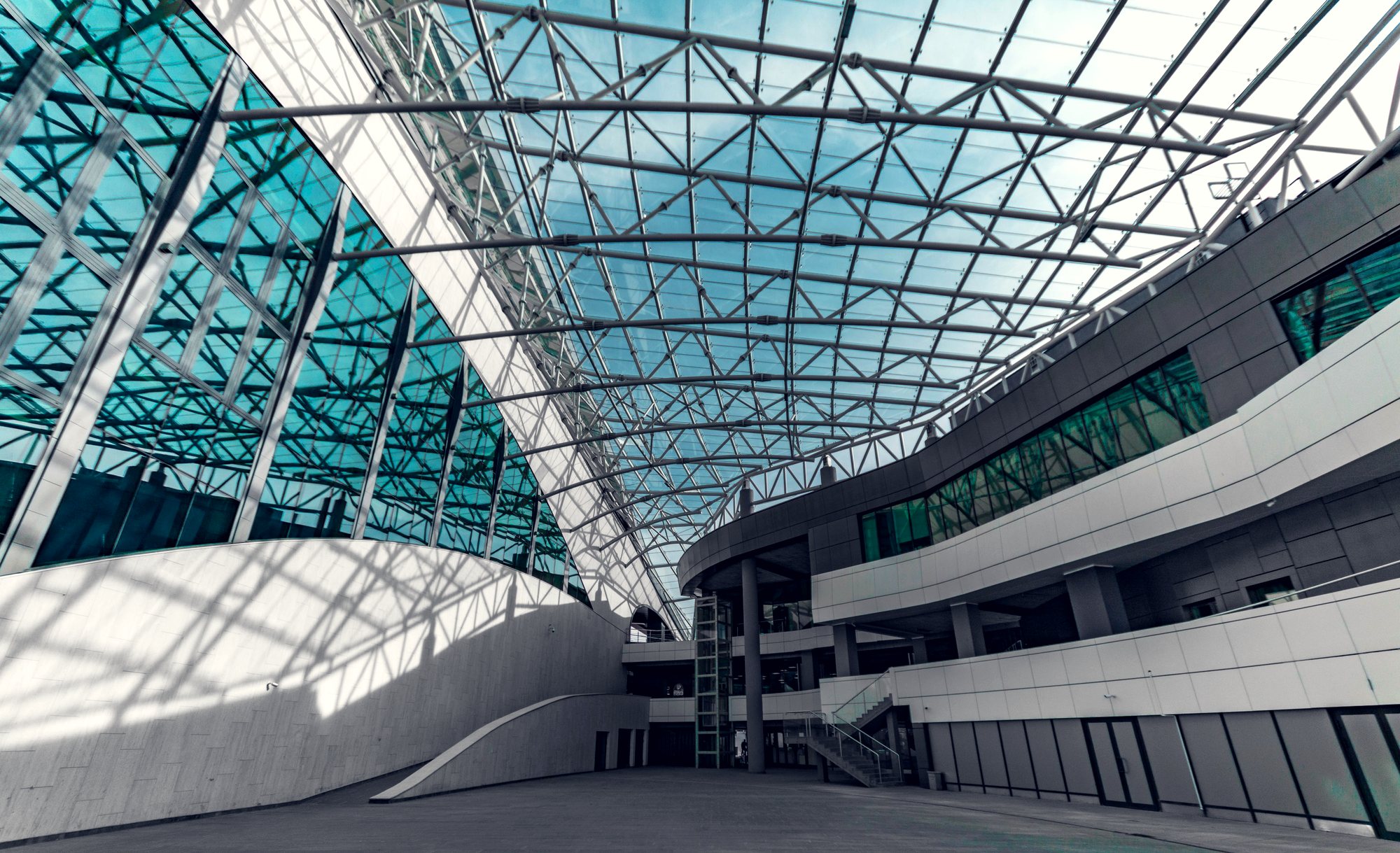 A modern glass walkway inside a public building at dusk